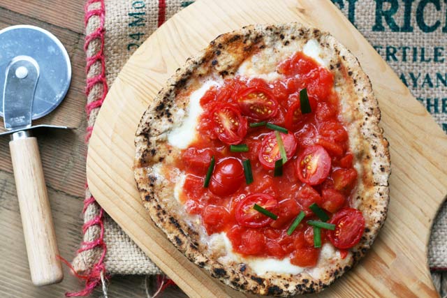 意式皮塔披萨。新鲜的大蒜和西红柿使这个披萨吃起来像意式烤面包。YUM !