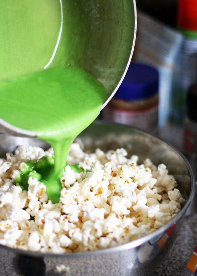 将绿色的棉花糖混合物添加到爆米花中，就可以做成圣诞树爆米花了!