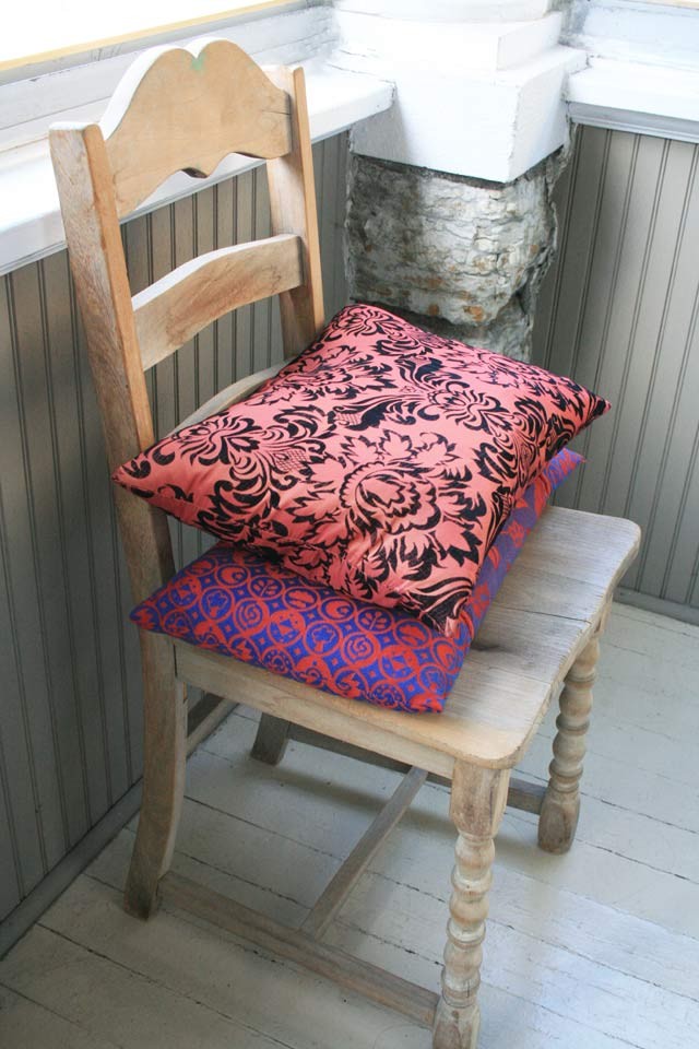 一把简单的复古木椅和两个彩色枕头。都是在旧货店找到的。